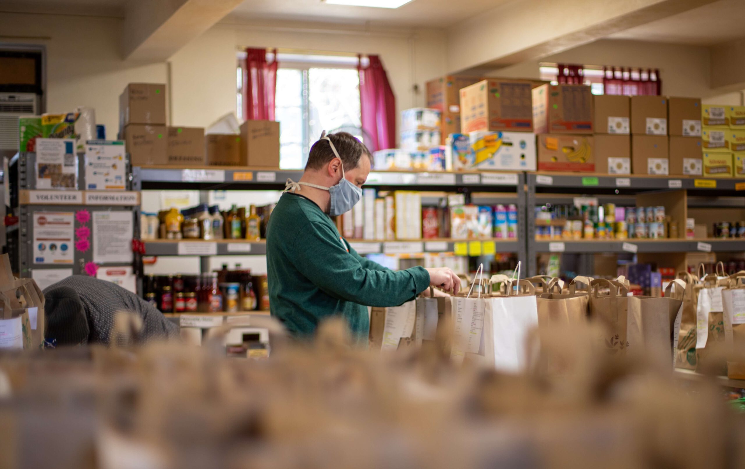 ACTS man with mask sorting through shelves